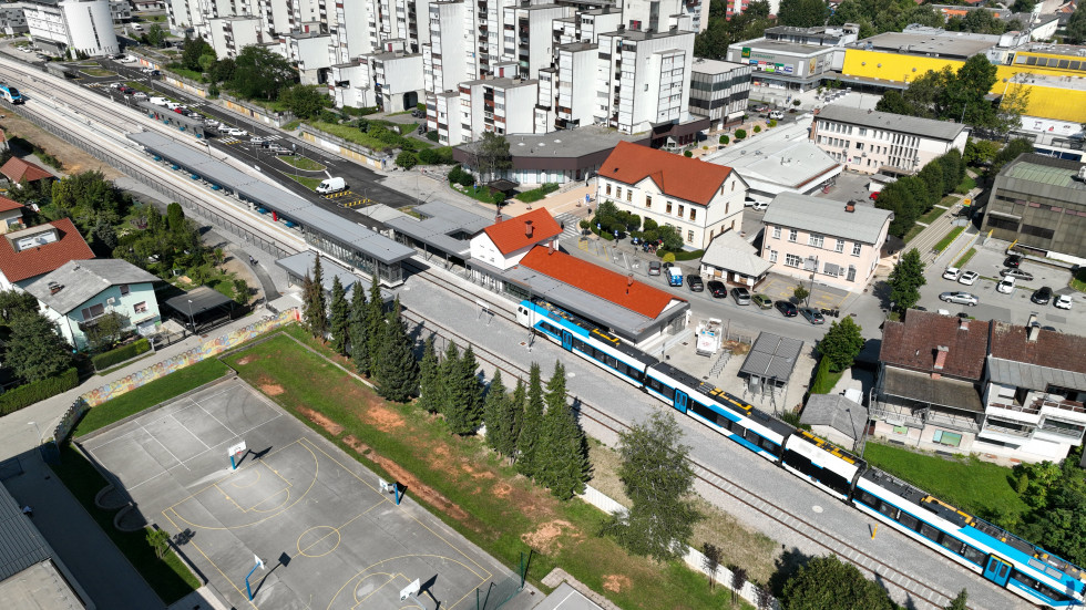 Posnetek železniške postaje iz zraka, prihod novega Stadlerjevega vlaka na postajo.