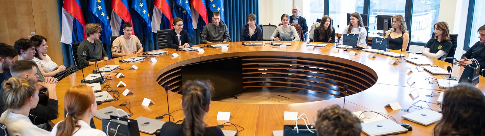 Dijaki in dijakinje sedijo za okroglo mizo, za katero običajno sedijo ministri in ministrice med sejo vlade