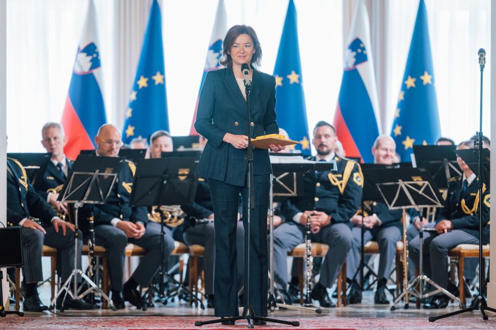 Ministrica Tanja Fajon stoji za mikrofonom, govor