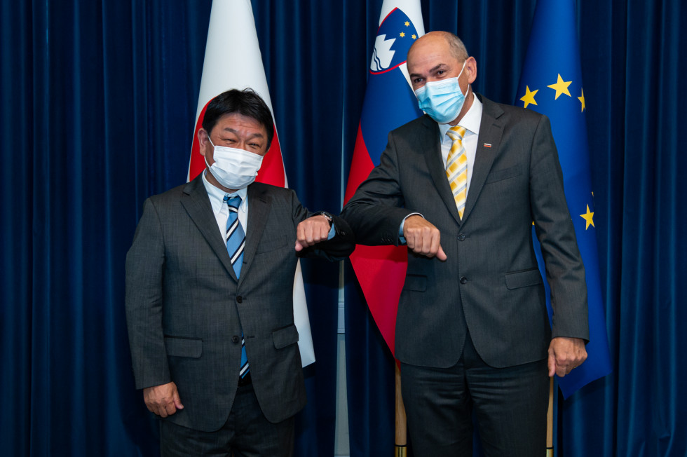 Japonski zunanji minister Toshimitsu Motegi in predsednik vlade Janez Janša, v ozadju japonska, slovenska in evropska zastava.