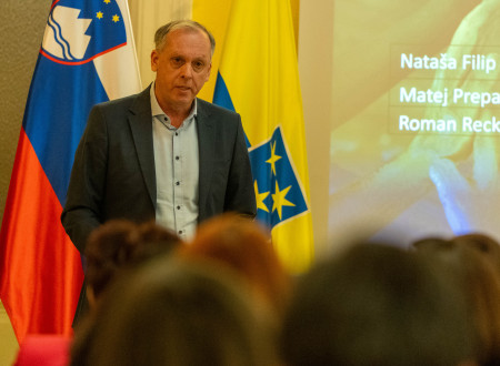Jurij Rojc nagovarja udeležence, zadaj zastave