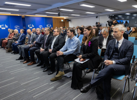 Udeleženci in gostje konference sedijo na stolih v dvorani