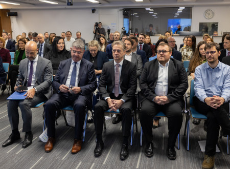 Udeleženci in gostje konference sedijo na stolih v dvorani