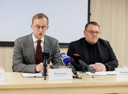 Jamnik in Maljevac sedita za mizo, na mizi mikrofoni