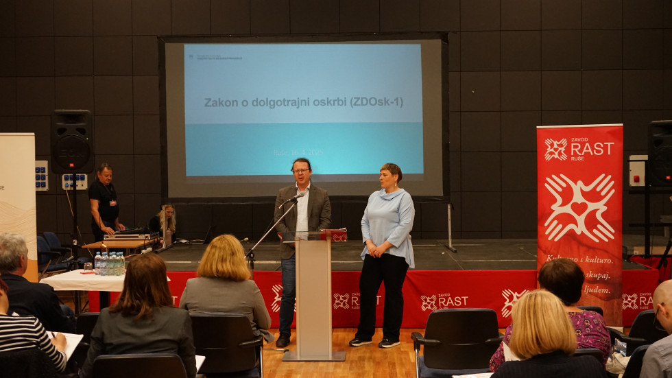 Predstavnika ministrstva stojita pred govorniškim pultom