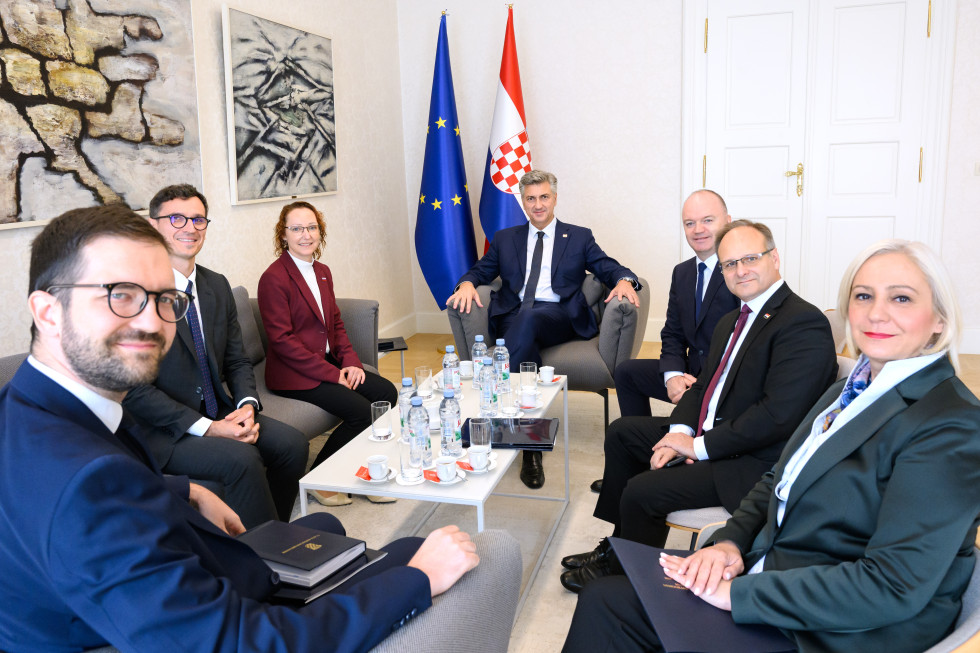Sprejem pri hrvaškem predsedniku vlade, sogovorniki sedijo za klubsko mizo, v ozadju hrvaška in evropska zastava. 