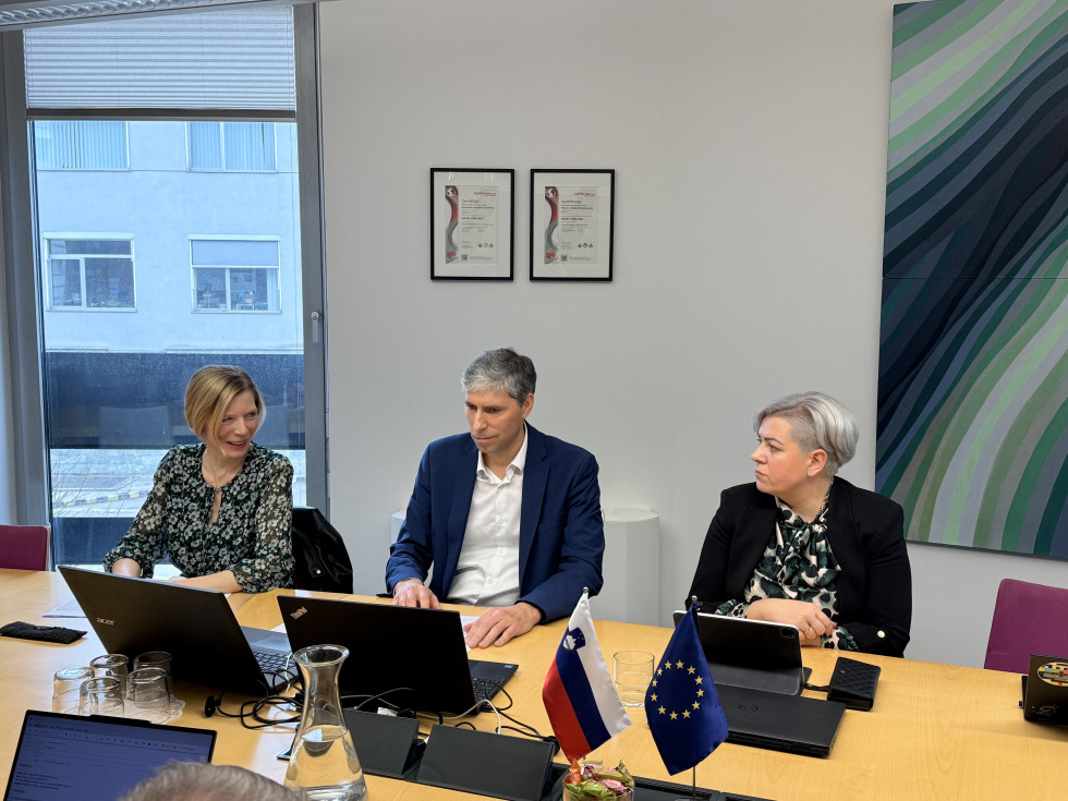 Moški in dve ženski sedijo za mizo. Pred njimi prenosni računalniki.