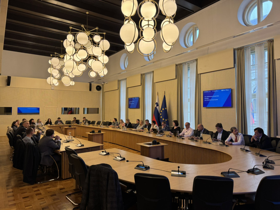 Udeleženci posveta sedijo v veliki dvorani Generalnega sekretariata Vlade.