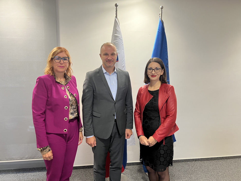 Standing in front of the flags of Slovenia and the EU from left to right: Vesna Nahtigal, Aleš Cantarutti, Dr Emilija Stojmenova Duh