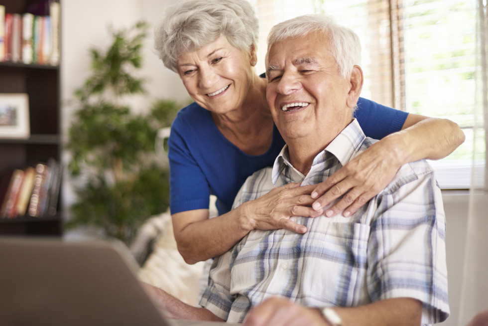 Zadovoljen starejši par za prenosnim računalnikom