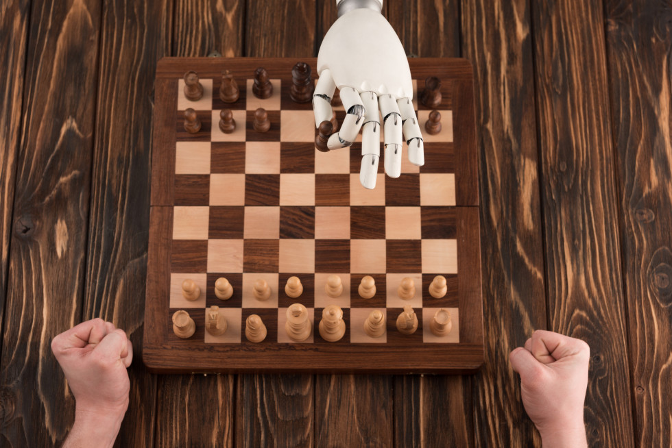 Človek in robot igrata šah.