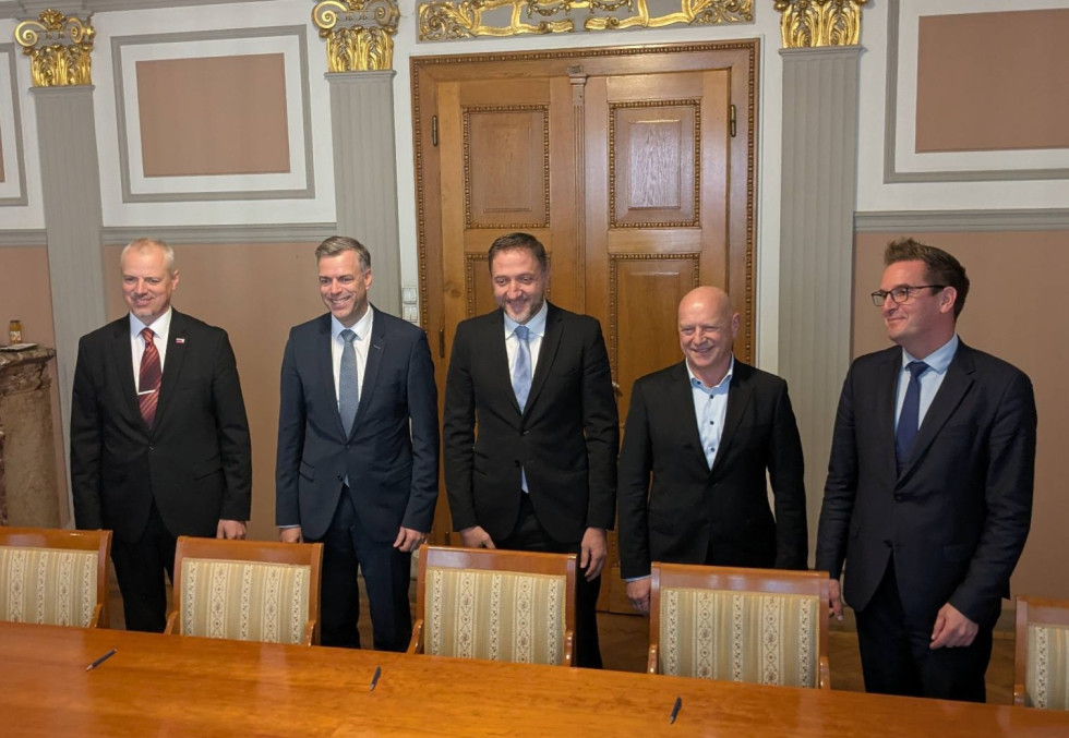 Podpisniki sporazuma skupaj stojijo in pozirajo fotografom