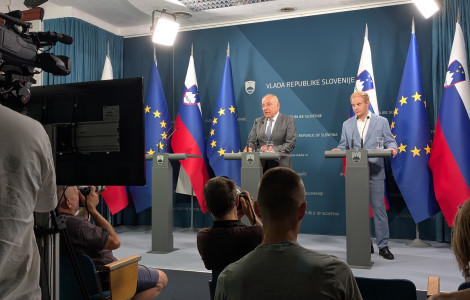 Novinarska konferenca o predlogu Zakona o Nacionalnem demografskem skladu (The minister and the state secretary are standing on stage and speaking in a hall.)