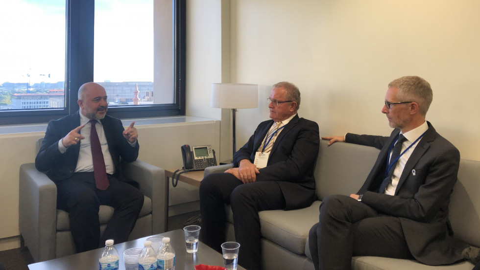Državni sekretar Metod Dragonja in guverner Banke Slovenije Boštjan Vasle sedita na sedežni garnituri in se pogovarjata s predstavnikom Mednarodnega denarnega sklada