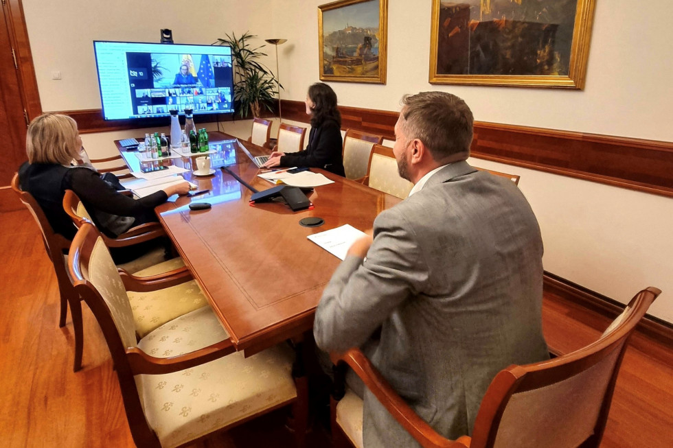 Minister s sodelavkama sedi v pisarni in prek video povezave sodeluje na zasedanju finančnih ministrov