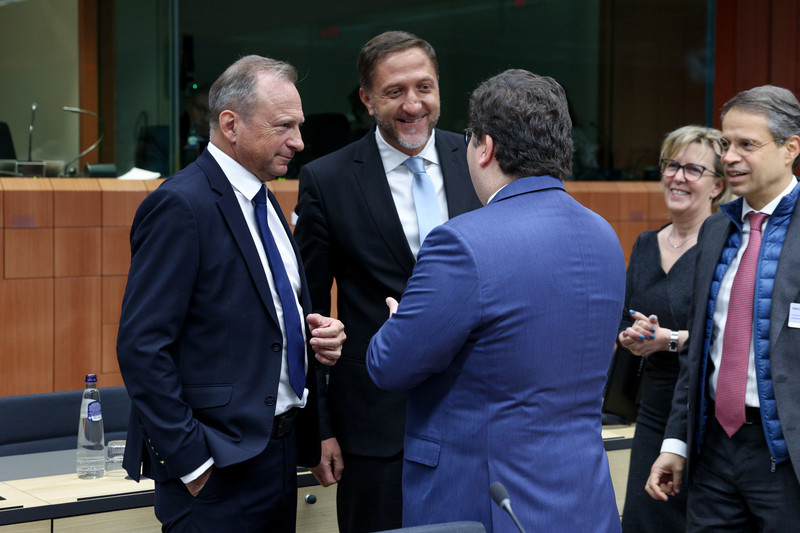 Trije moški stojijo in se pogovarjajo. 