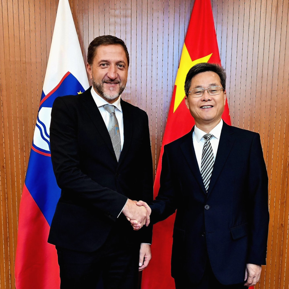 Ministra se rokujeta pred zastavama obeh držav