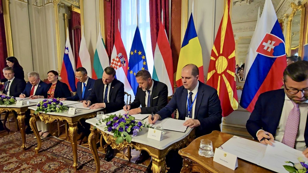 Predstavniki držav sedijo in podpisujejo memorandum