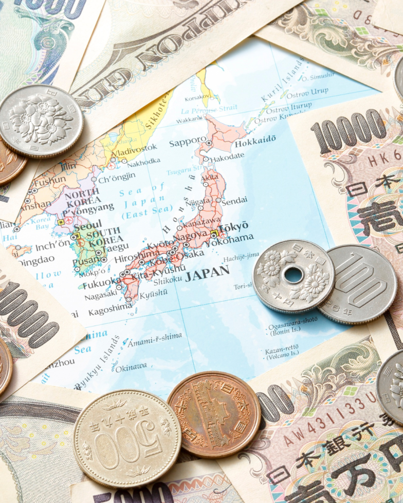Map of Japan surrounded by coins and banknotes of the yen currency.