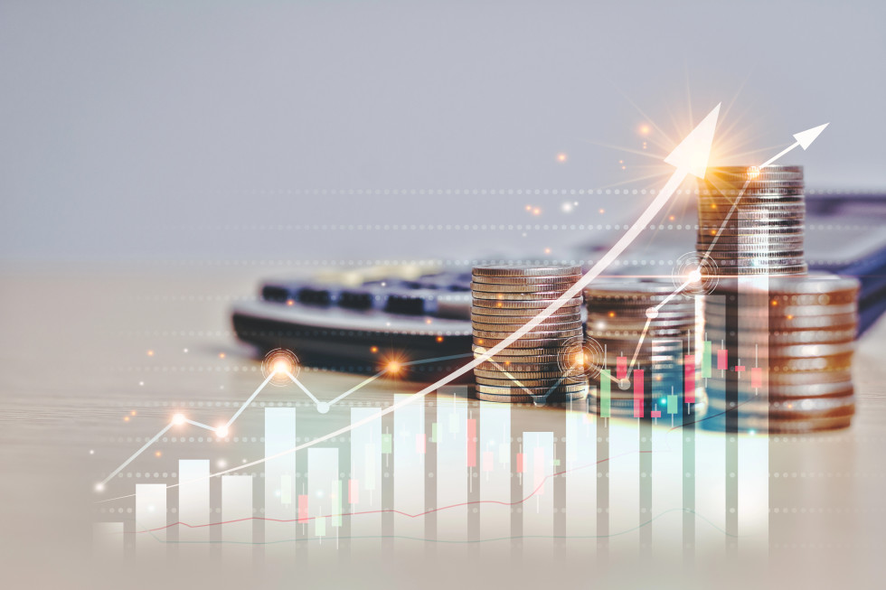 Grafika s stolpičnim in črtnim grafikonom, kjer se vrednosti zvišujejo, v ozadju je kalkulator