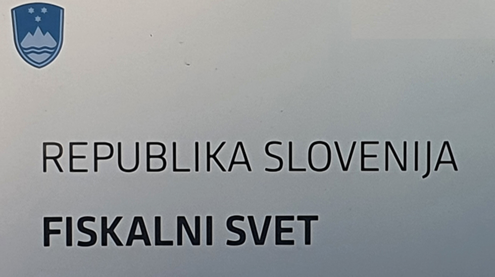 Napisna tabla Fiskalnega sveta. Sivo srebrna podlaga, levo zgoraj moder slovsneki grb, spodaj črn napis Republika Slovenija, Fiskalni svet. 