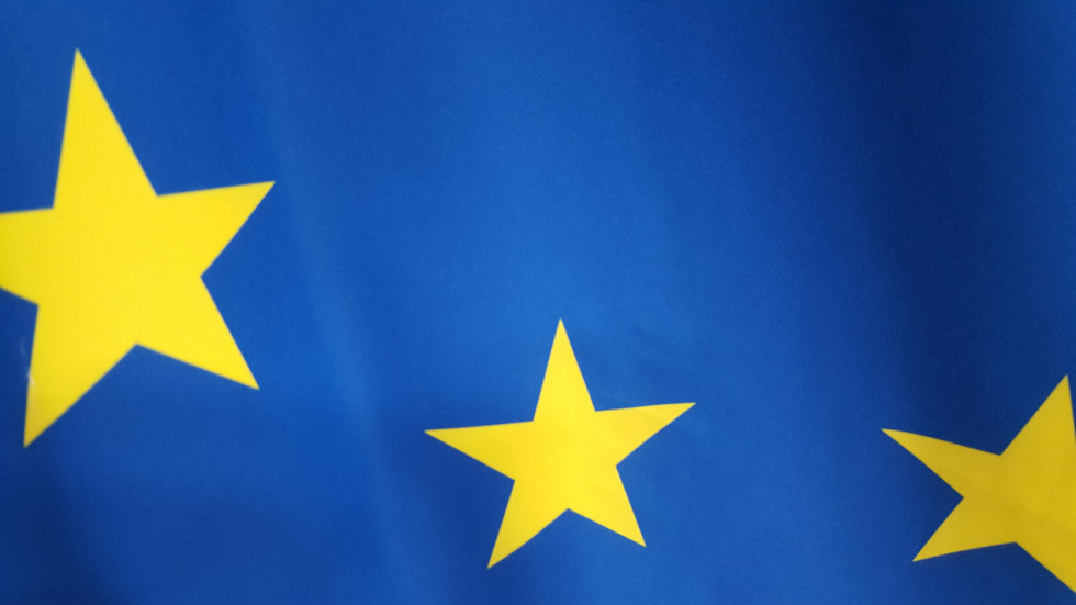 Izsek zastave EU. Modra podlaga, na kateri so rumene petokrake zvezde.