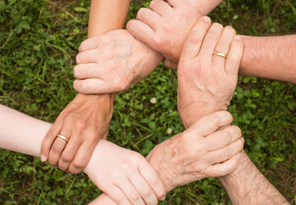 Šest dlani drži druga drugo v obliki kroga, s čimer izkazujemo solidarnost in pomoč