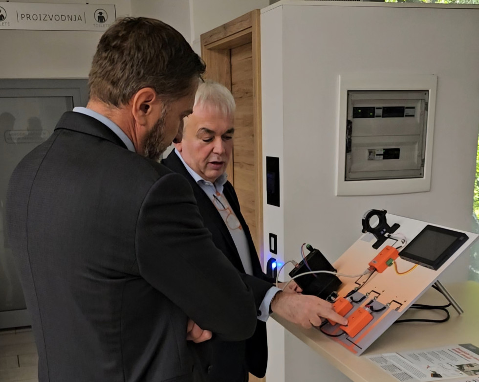 Ministru Kloemnu Boštjančiču direktor podjetja Robotina predstavlja njihove produkte.