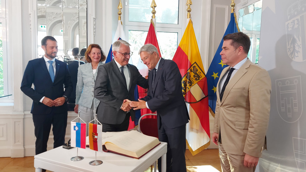 The Minister and the Governor shaking hands at the flags.