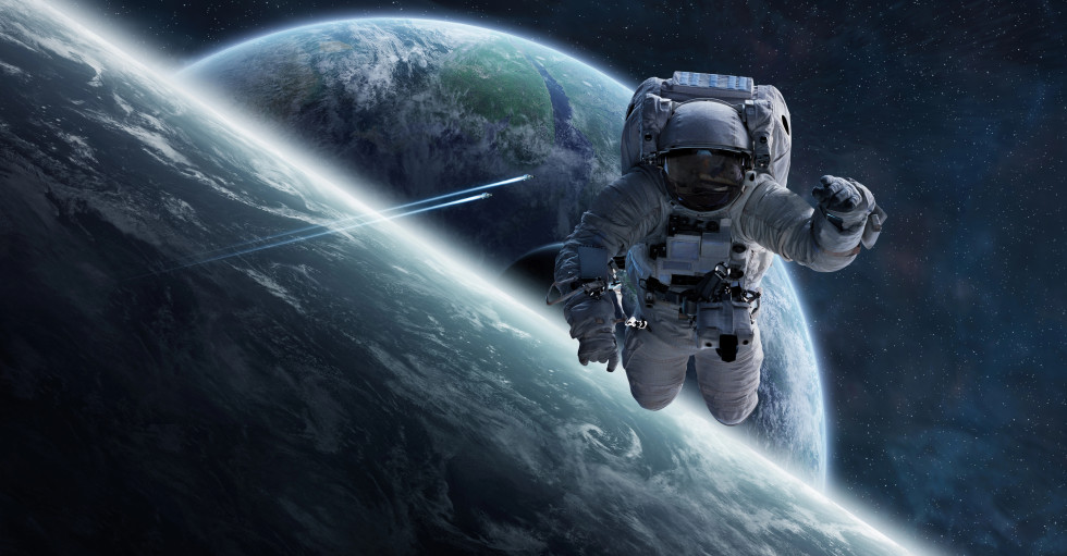 Astronavt v vesolju in v ozadju Zemlja