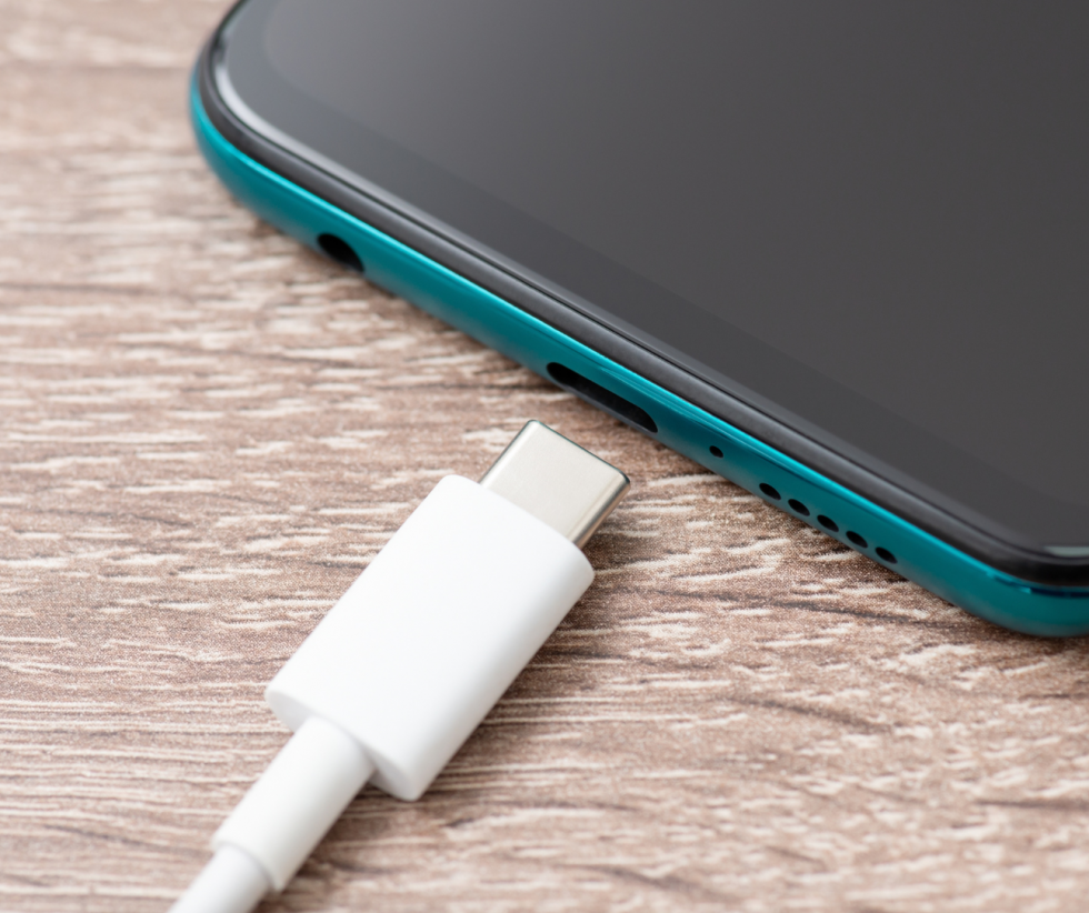 polnilec vrste USB C ob prenosnem telefonu črno modre barve