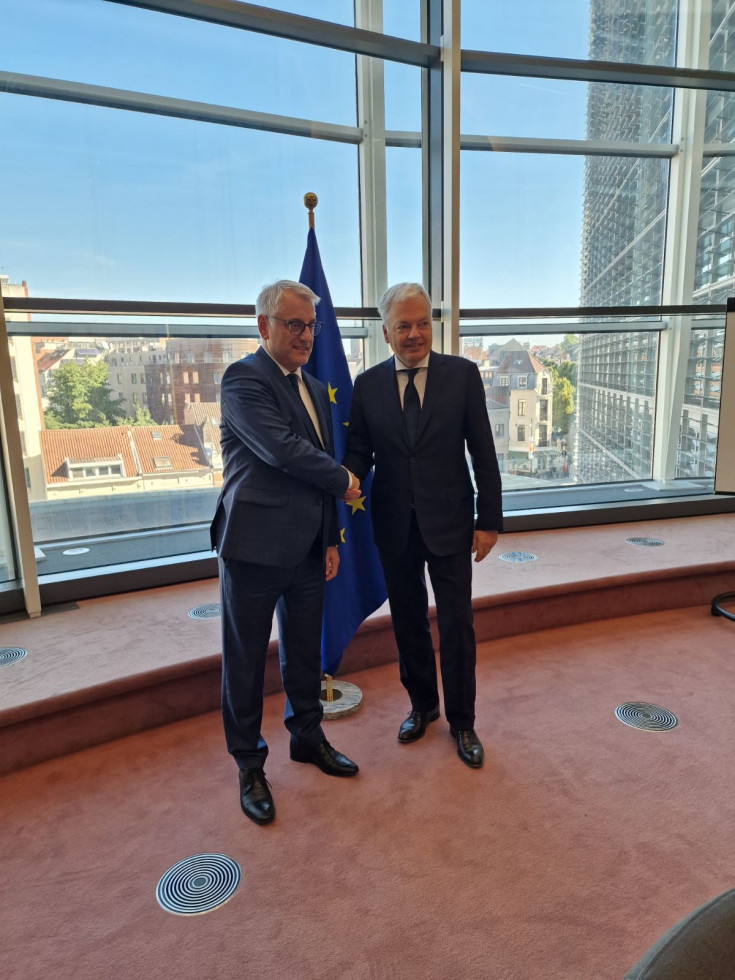 minister med rokovanjem s komisarjem pred zastavami