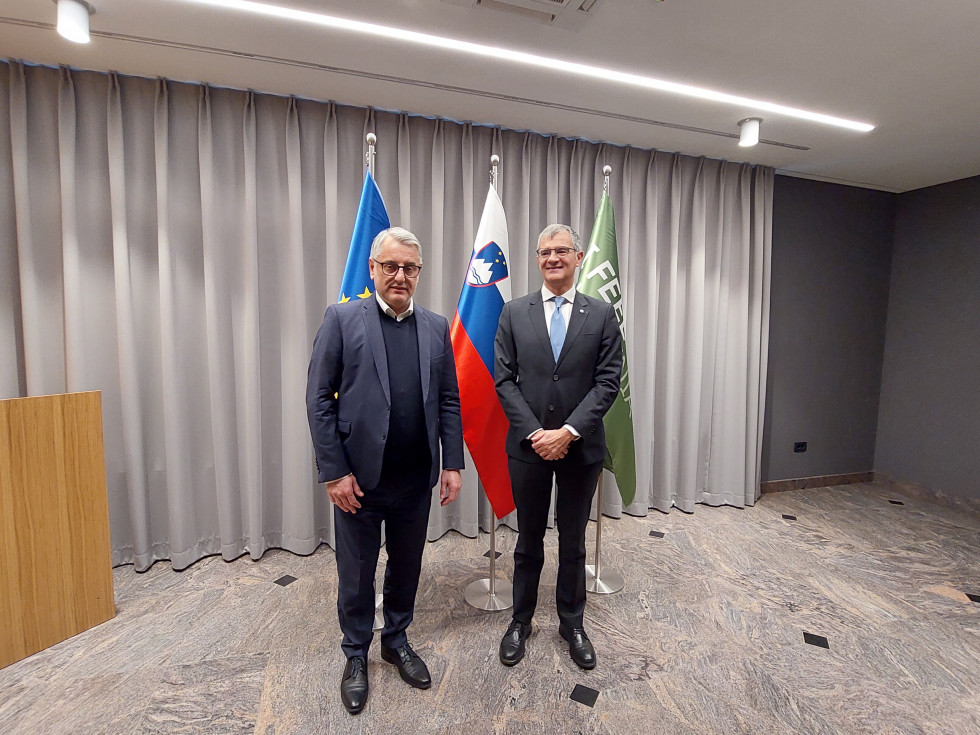 Minister Han and Director Saccoccia in front of the flags