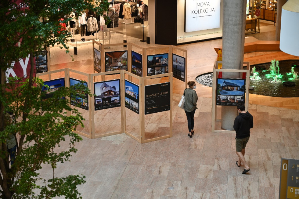 pogled z nadstropja na razstavne panoje razstave Bivanje z lesom v nakupovalnem središču Aleja v Ljubljani