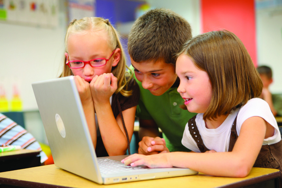 kids watching something on silver laptop