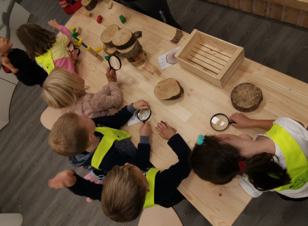Otroci za leseno mizo z lesenimi igračami s ptičje perspektive