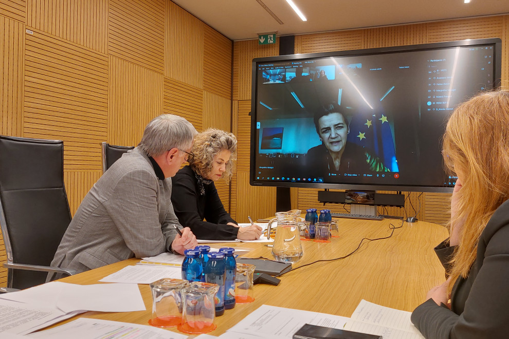 Ministry officials in the conference room and the Commissioner on the screen