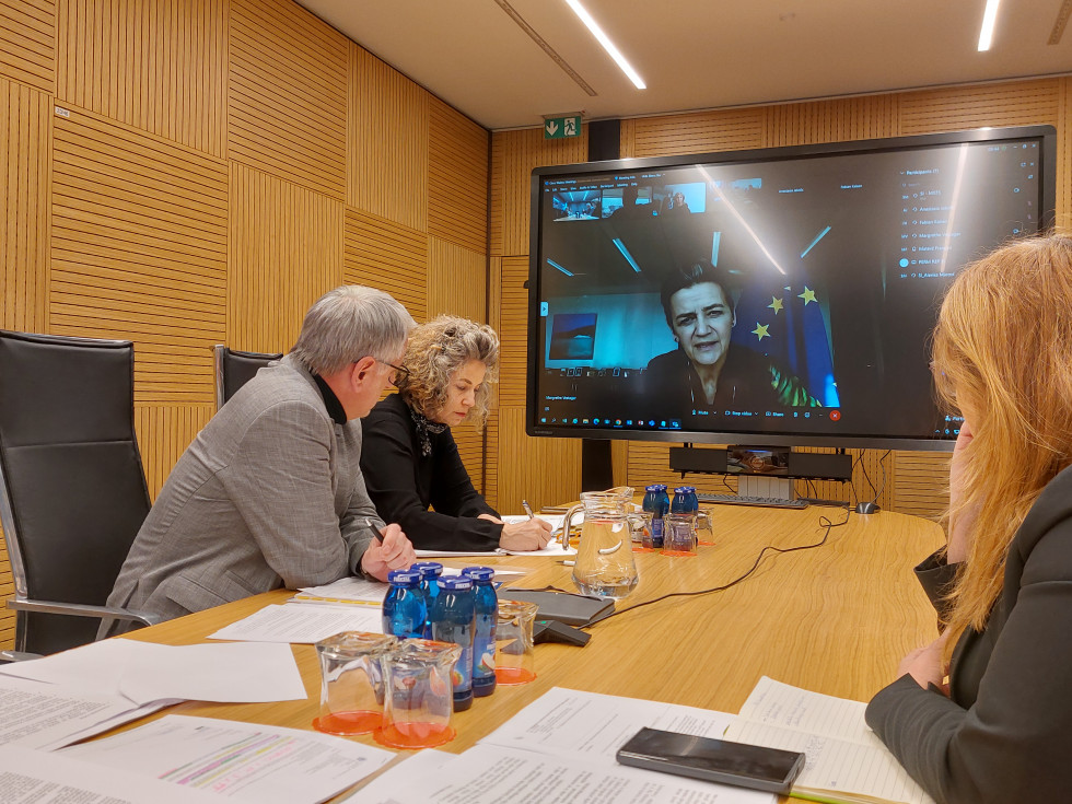 Ministry officials in the conference room and the Commissioner on the screen