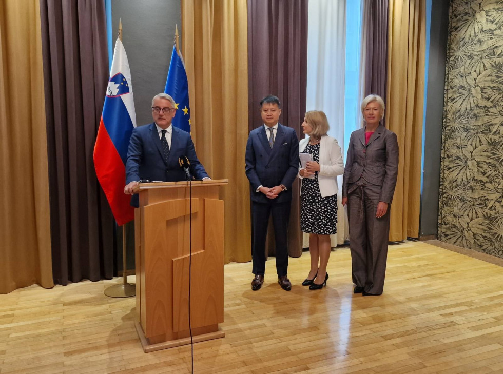 Minister Han at the lectern, flanked on the right by Daren Tang, translator, and Karin Žvokelj.