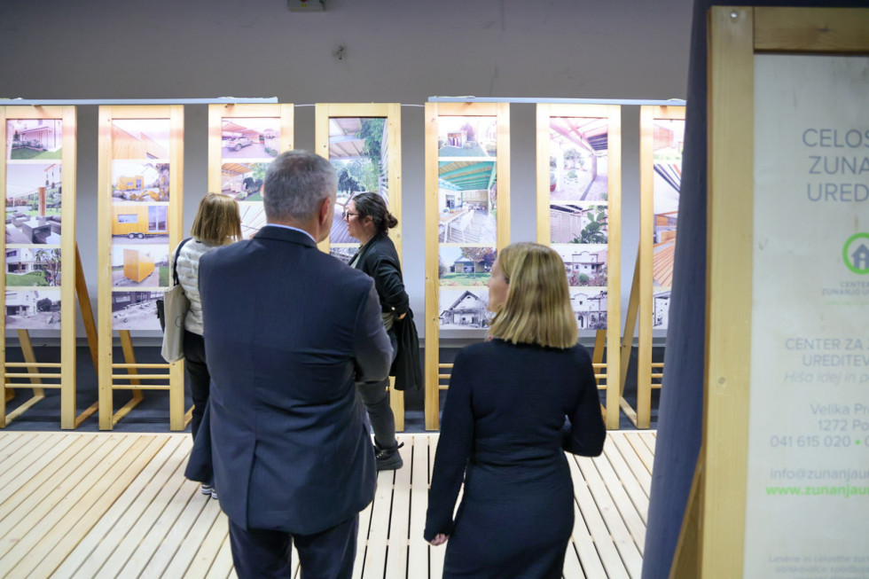 Državni sekretar mag. Židan stoji zraven ženske. Skupaj si ogledujeta razstavo izdelkov. 