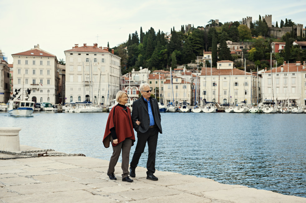 starejši par, ki se sprehaja ob morju v Piranu