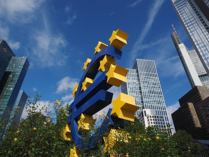 Znak plačilnega sredstva evro med stavbami pred Evropsko centralno banko v Frankfurtu