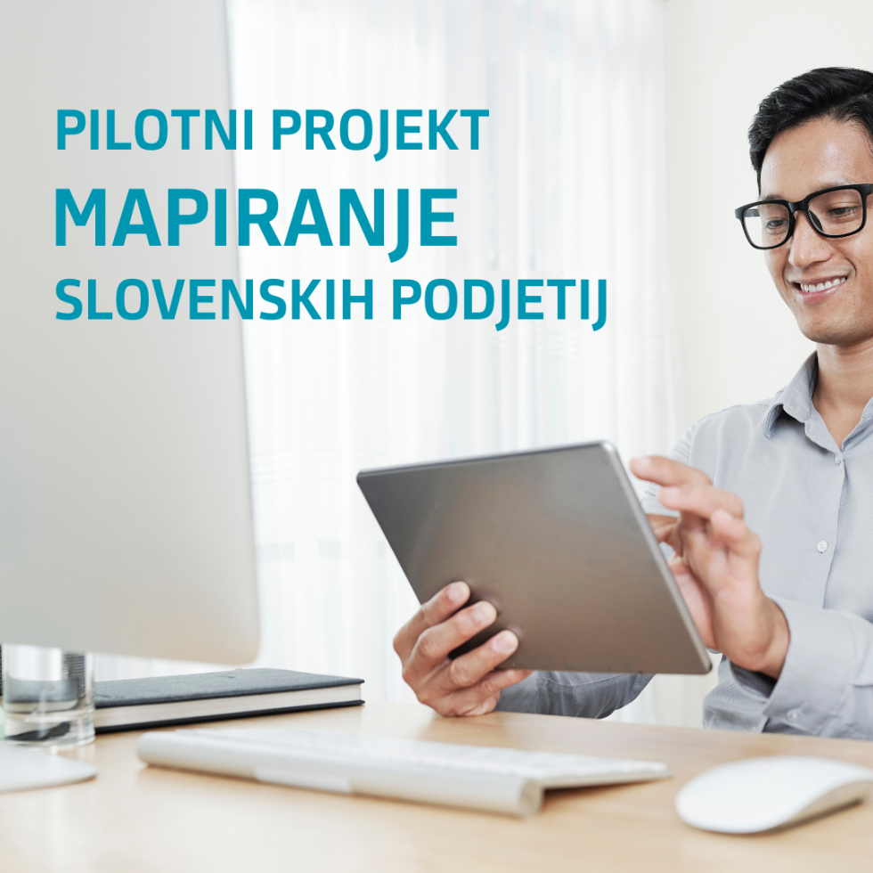 Moški sedi za mizo in drži tablico. V levem kotu fotografije napis - Pilotni projekt Mapiranje slovenskih podjetij