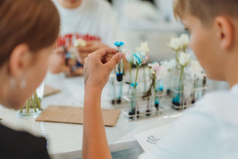 Osnovnošolke in osnovnošolci sodelujejo pri poskusu v laboratoriju.
