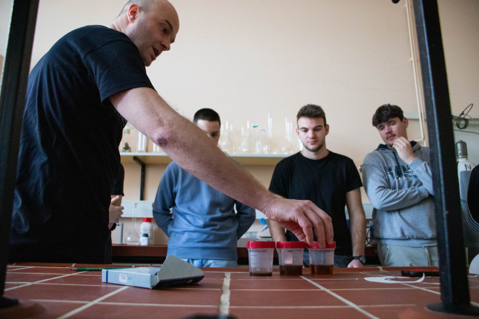Raziskovalec v laboratoriju predstavlja dijakom svoje delo.