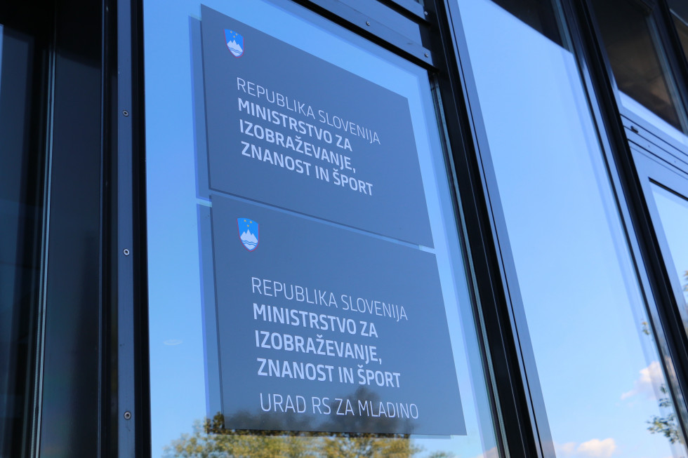 Tabla z napisom Ministrstvo za izobraževanje, znanost in šport ter grbom Republike Slovenije.