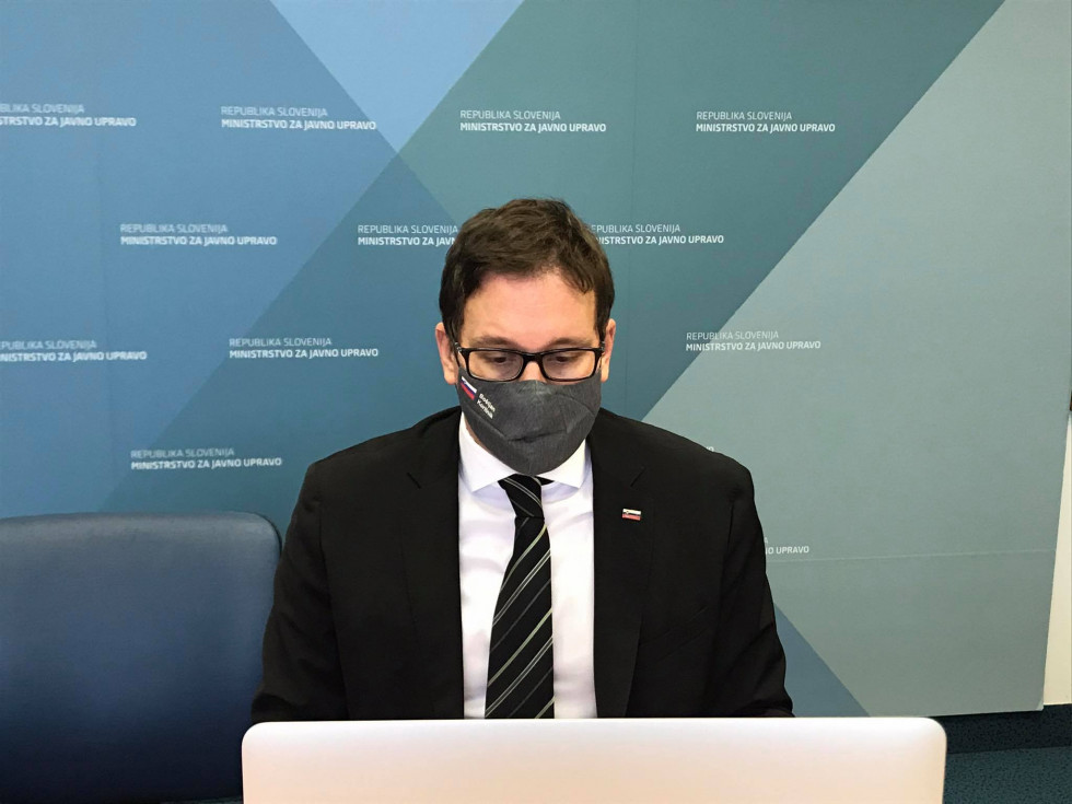 Minister Boštjan Koritnik sedi pred računalniškim monitorjem