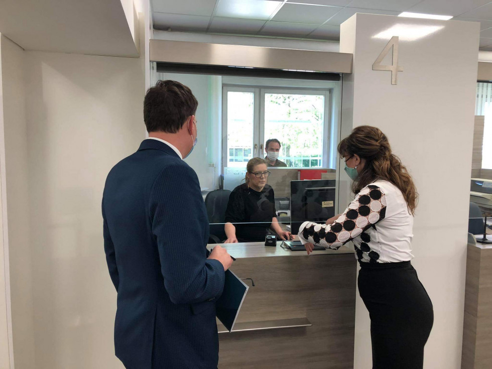 minister stoji ob okencu za stranke