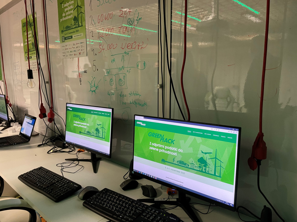 Fotografija računalnikov, na katerih je na zaslonu logotip dogodka Green Hack