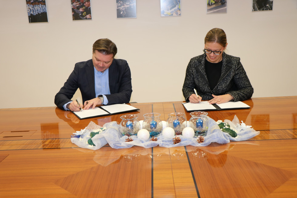 Ministrica in dekan podpisujeta sporazum, sedeča za mizo